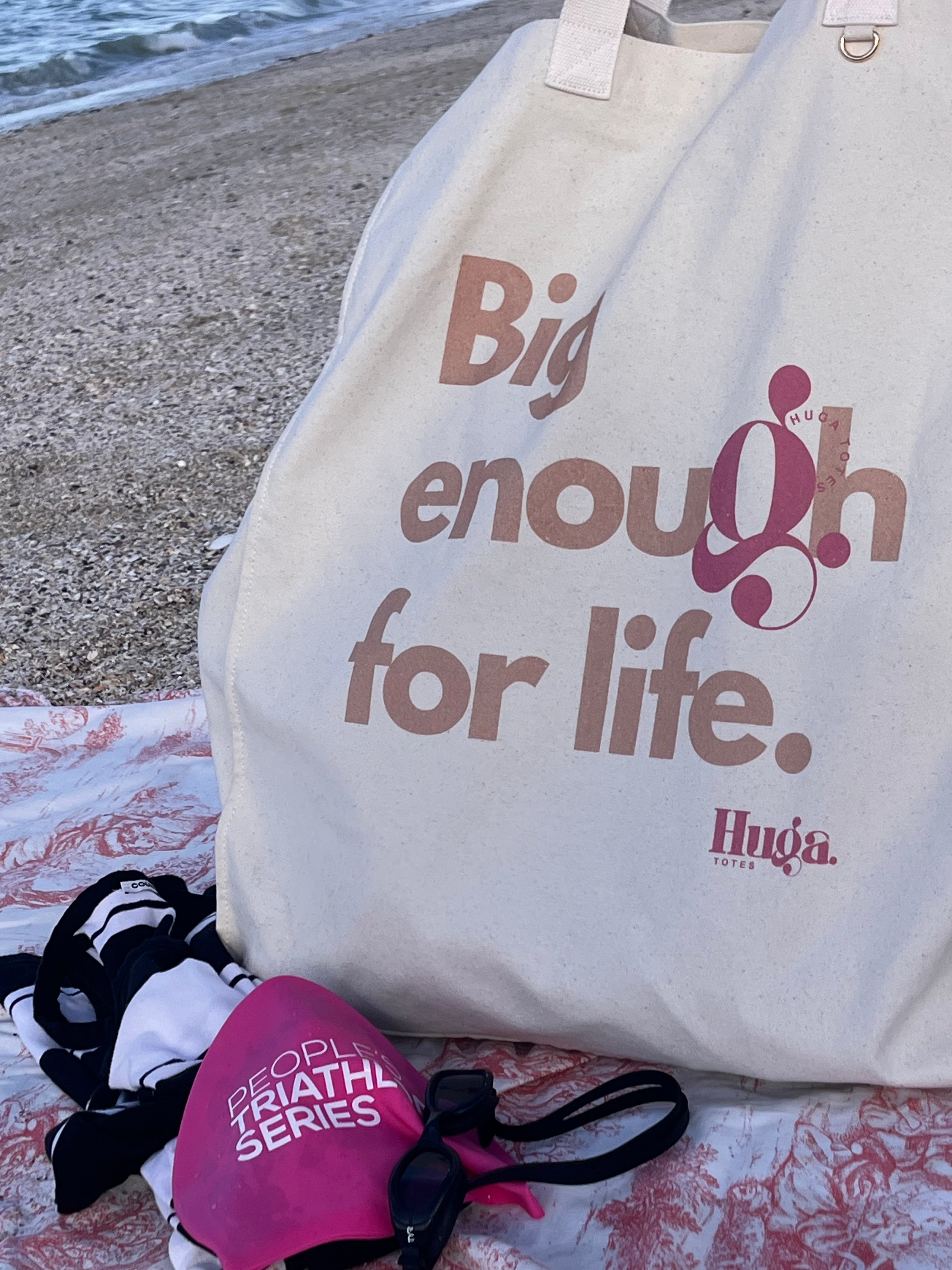Tote bag with 'Big enough for life' text on a beach